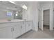 Bathroom features a double sink vanity with white cabinets, a large mirror, and tile floors at 5036 Blanket Flower St, Apopka, FL 32712