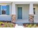 Close-up of a stylish front door with stone pillar accents and well-maintained landscaping at 5036 Blanket Flower St, Apopka, FL 32712