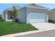 View of attached two-car garage with well-kept lawn and clean driveway approach at 5036 Blanket Flower St, Apopka, FL 32712