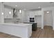 Open-concept kitchen with white countertops, stainless steel appliances, and bar stool seating at 5036 Blanket Flower St, Apopka, FL 32712