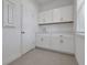 Convenient laundry room with white cabinets, a utility sink, and ample counter space at 5036 Blanket Flower St, Apopka, FL 32712