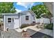 This backyard has a small patio with gravel landscaping, a quaint stump, and beautiful pink flowering bushes at 506 Richard St, Leesburg, FL 34748