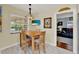 Inviting dining area with a window and a view into the living room with wood-style flooring at 506 Richard St, Leesburg, FL 34748
