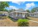 Single-story home with a covered carport and walkway with an awning over the entry and front windows at 506 Richard St, Leesburg, FL 34748