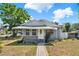 Charming single-story home with well-maintained landscaping and a welcoming front porch with awning at 506 Richard St, Leesburg, FL 34748