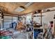 Spacious garage featuring a plywood ceiling, concrete walls, and storage shelves, offering ample space for projects and storage at 506 Richard St, Leesburg, FL 34748