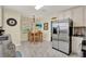 Sunlit eat-in kitchen features stainless steel refrigerator, tile floors, and breakfast table at 506 Richard St, Leesburg, FL 34748