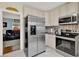 Bright kitchen features stainless steel appliances and adjacent living room view at 506 Richard St, Leesburg, FL 34748