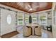 Cozy sun room features wood ceiling, tiled floors, a ceiling fan, and great natural light at 506 Richard St, Leesburg, FL 34748