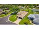 Aerial view of home with mature landscaping, screen lanai, and circular drive in well-maintained neighborhood at 5075 China Sea Dr, Tavares, FL 32778