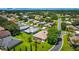 Aerial view of back of house, with screened in lanai, landscaping, and circular drive in green neighborhood at 5075 China Sea Dr, Tavares, FL 32778