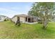 Backyard featuring a screened-in patio and a green lawn at 5075 China Sea Dr, Tavares, FL 32778