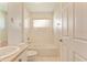 Bright bathroom featuring a sink, toilet, and bathtub with tiled walls and floors at 5075 China Sea Dr, Tavares, FL 32778