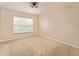 Neutral bedroom with a large window overlooking the yard and neutral carpeting at 5075 China Sea Dr, Tavares, FL 32778