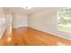 Bright bedroom with wood floors, large window, and access to closet and hallway at 5075 China Sea Dr, Tavares, FL 32778