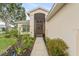 Welcoming front entrance with a screen door and decorative landscaping at 5075 China Sea Dr, Tavares, FL 32778