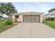 Attached two-car garage featuring a concrete driveway and manicured landscaping at 5075 China Sea Dr, Tavares, FL 32778