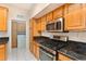 Updated kitchen features stainless steel appliances, wood cabinetry, and granite countertops at 5075 China Sea Dr, Tavares, FL 32778
