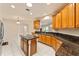 Spacious kitchen features tile flooring, center island, wood cabinets and granite countertops at 5075 China Sea Dr, Tavares, FL 32778