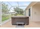Relax in privacy on this screened lanai, featuring a hot tub and views of the lush greenery at 5075 China Sea Dr, Tavares, FL 32778