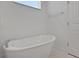 Modern bathroom with a freestanding tub, white walls, and a window, offering a serene and bright atmosphere at 5105 Blanket Flower St, Apopka, FL 32712