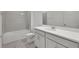 A clean, bright bathroom features a white vanity, toilet, tub with white tile surround, and marble-look flooring at 5105 Blanket Flower St, Apopka, FL 32712