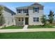 Charming two-story home with light exterior, manicured lawn, and dark shutters on a sunny day at 5105 Blanket Flower St, Apopka, FL 32712