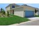 Beige home with a blue two-car garage, and an ample lawn and landscaped area at 5105 Blanket Flower St, Apopka, FL 32712