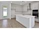 Modern kitchen with a large island, white cabinetry, stainless steel appliances, and outdoor access at 5105 Blanket Flower St, Apopka, FL 32712