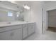 Bright bathroom with double vanity, large mirror, and a view into the glass shower at 5125 Waypointe Blvd, Apopka, FL 32712