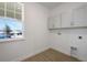 Bright laundry room with white cabinets, window, and convenient in-wall utility hookups at 5125 Waypointe Blvd, Apopka, FL 32712