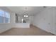 Open-concept living room with a view of the gray kitchen with an island and a modern light fixture at 5125 Waypointe Blvd, Apopka, FL 32712
