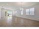 Spacious living room with wood-look tile, white walls, large windows and modern lighting at 5125 Waypointe Blvd, Apopka, FL 32712