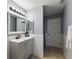 Well-lit bathroom features a vanity with sink, a large mirror, and beadboard accent paneling at 529 Ed Douglas Rd, Groveland, FL 34736