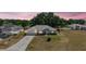 Twilight view of a single-story home with a well-maintained lawn and an attached two-car garage at 529 Ed Douglas Rd, Groveland, FL 34736