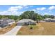 Angle aerial view of a single-story home with a manicured lawn, two car garage, and mature landscaping at 529 Ed Douglas Rd, Groveland, FL 34736