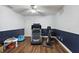 Exercise room with white and blue walls, wood floors, and exercise equipment at 529 Ed Douglas Rd, Groveland, FL 34736