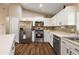 A well-lit kitchen featuring stainless steel appliances, white cabinets, and a stylish backsplash at 529 Ed Douglas Rd, Groveland, FL 34736