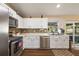 Modern kitchen with stainless steel appliances, sleek white cabinetry, and a stone tile backsplash at 529 Ed Douglas Rd, Groveland, FL 34736