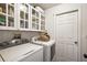 Functional laundry room with washer, dryer, and white cabinets for storage at 529 Ed Douglas Rd, Groveland, FL 34736