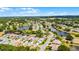 Aerial view of a residential neighborhood with winding roads, lush trees, and scenic lake views at 5500 Laver St, Leesburg, FL 34748