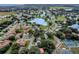 Picturesque aerial view of community with a beautiful lake, lush trees, and well-maintained homes at 5500 Laver St, Leesburg, FL 34748