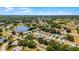 An aerial view showcasing a community with lake access, mature trees, and well-maintained lawns at 5500 Laver St, Leesburg, FL 34748