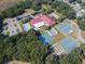Aerial view showcasing the community center, pool, tennis courts, shuffleboard, and parking areas at 5500 Laver St, Leesburg, FL 34748