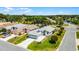 Aerial view of property showcasing well-manicured lawn, mature trees, and a two car garage at 5500 Laver St, Leesburg, FL 34748
