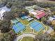 Aerial view highlighting the tennis courts, shuffleboard courts, pool and clubhouse in a mature setting at 5500 Laver St, Leesburg, FL 34748
