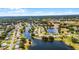 An aerial view showcasing a community with lake access, mature trees, and well-maintained lawns at 5500 Laver St, Leesburg, FL 34748