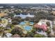 Aerial view overlooking community tennis courts, clubhouse, pool and a picturesque lake at 5500 Laver St, Leesburg, FL 34748