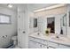 Well-lit bathroom with dual sinks, white cabinetry, and ample mirror space at 5500 Laver St, Leesburg, FL 34748