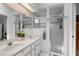 Modern bathroom with dual sinks, white cabinetry, and a walk-in shower with glass door at 5500 Laver St, Leesburg, FL 34748